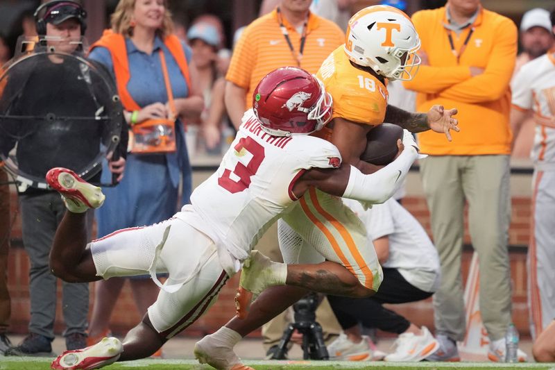 Tennessee running back DeSean Bishop (18) is tackled by Arkansas defensive back Larry Worth III (3) during a college football game between Tennessee and Arkansas at Neyland Stadium in Knoxville, Tennessee on Oct. 11, 2025.
