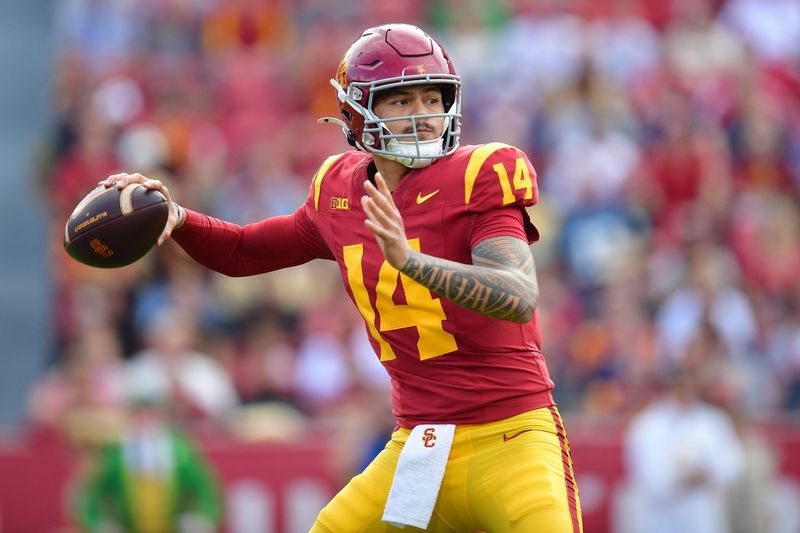 Nov 30, 2024; Los Angeles, California, USA; Southern California Trojans quarterback Jayden Maiava (14) throws against the Notre Dame Fighting Irish during the first half at the Los Angeles Memorial Coliseum. Mandatory Credit: Gary A. Vasquez-Imagn Images
