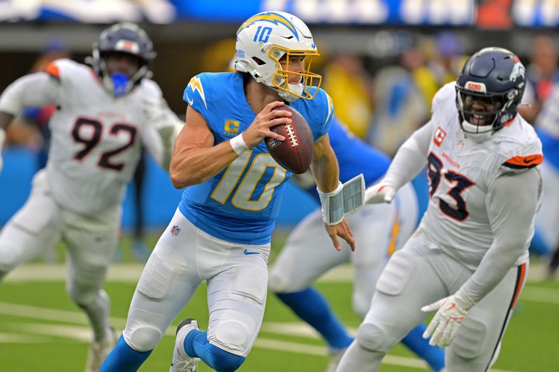Sep 21, 2025; Inglewood, California, USA; Los Angeles Chargers quarterback Justin Herbert (10) avoids Denver Broncos defensive tackle DJ. Jones (93) as he looks to pass in the first half at SoFi Stadium. Mandatory Credit: Jayne Kamin-Oncea-Imagn Images