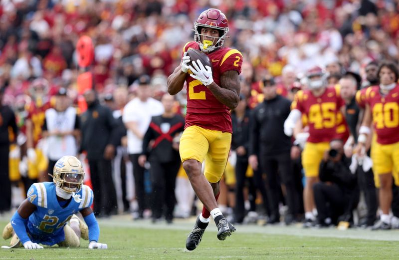 Nov 18, 2023; Los Angeles, California, USA; USC Trojans wide receiver Brenden Rice (2) catches a touchdown against UCLA Bruins defensive back Jaylin Davies (24) during the second quarter at United Airlines Field at Los Angeles Memorial Coliseum. Mandatory Credit: Jason Parkhurst-USA TODAY Sports