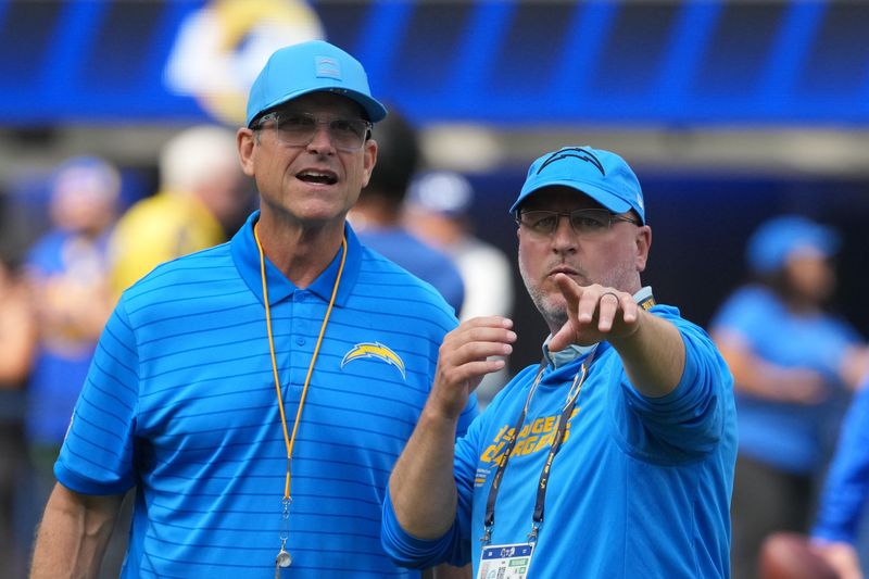 Aug 16, 2025; Inglewood, California, USA; Los Angeles Chargers coach Jim Harbaugh (left) and general manager Joe Hortiz react during the game against the Los Angeles Rams at SoFi Stadium. Mandatory Credit: Kirby Lee-Imagn Images