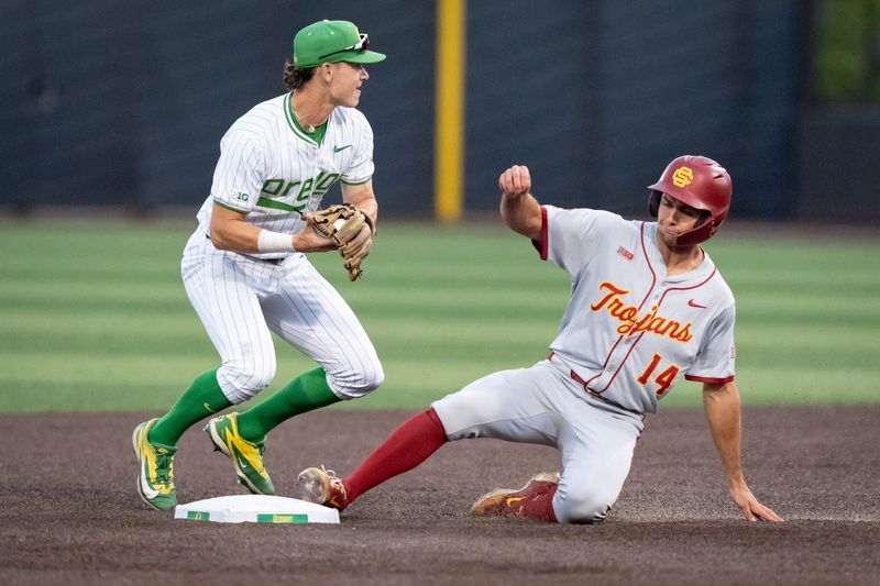 Oregon infielder Maddox Molony, left, forces out USC outfielder Jack Basseer at second base as the Oregon Ducks host the USC Trojans on May 14, 2026, in Eugene, Oregon.