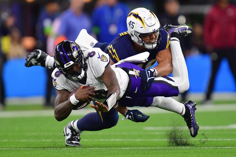 Nov 26, 2023; Inglewood, California, USA; Baltimore Ravens quarterback Lamar Jackson (8) is brought down by Los Angeles Chargers linebacker Tuli Tuipulotu (45) during the second half at SoFi Stadium. Mandatory Credit: Gary A. Vasquez-USA TODAY Sports