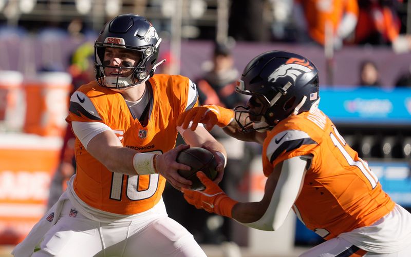 Denver Broncos quarterback Bo Nix fakes a hand off to running back RJ Harvey during first half action at Empower FIeld at Mile High in Denver, Colorado on Jan. 17, 2026.