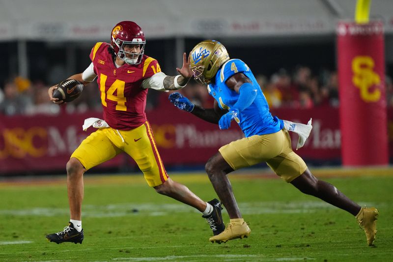 Nov 29, 2025; Los Angeles, California, USA; Southern California Trojans quarterback Jayden Maiava (14) carries the ball against UCLA Bruins defensive back Key Lawrence (4) in the second half at United Airlines Field at Los Angeles Memorial Coliseum. Mandatory Credit: Kirby Lee-Imagn Images