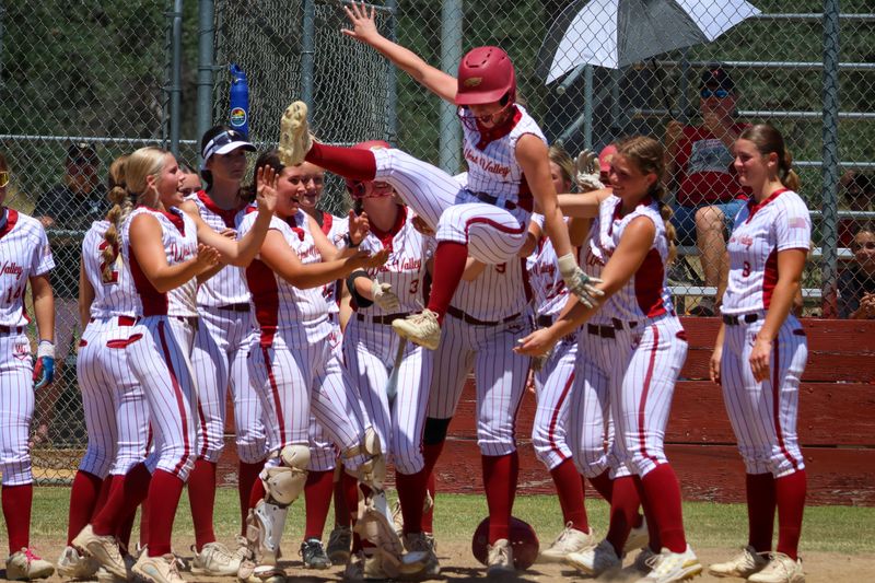 West Valley sophomore Coral Tozer jumps into her teammates at home plate after crushing a home run in a playoff game against Lassen. West Valley defeated Lassen 8-1 to clinch a spot in the section championship game. May 21, 2026.