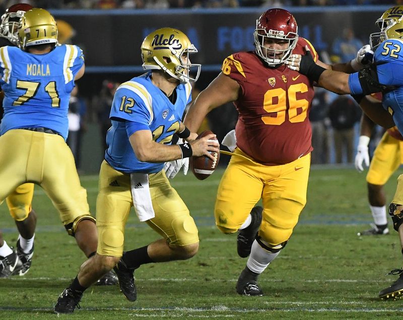 Nov 19, 2016; Pasadena, CA, USA; UCLA Bruins quarterback Mike Fafaul (12) is pressured by USC Trojans defensive tackle Stevie Tu'ikolovatu (96) in the second quarter of the game at the Rose Bowl. Mandatory Credit: Jayne Kamin-Oncea-USA TODAY Sports
