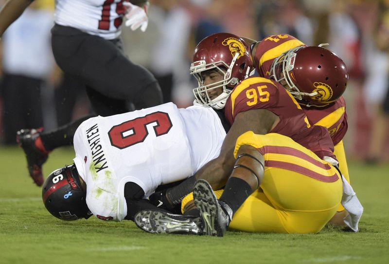 Sep 5, 2015; Los Angeles, CA, USA; Southern California Trojans defensive tackle Kenny Bigelow (95) tackles Arkansas Red Wolves quarterback Fredi Knighten (9) at Los Angeles Memorial Coliseum. Mandatory Credit: Kirby Lee-USA TODAY Sports