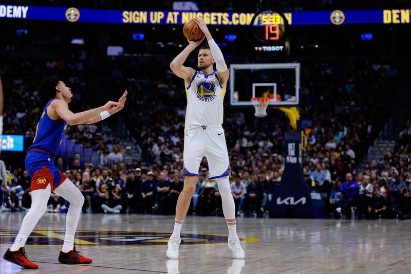 Mar 29, 2026; Denver, Colorado, USA; Golden State Warriors center Kristaps Porzingis (7) attempts a shot as Denver Nuggets guard Julian Strawther (3) defends in the second quarter at Ball Arena. Mandatory Credit: Isaiah J. Downing-Imagn Images