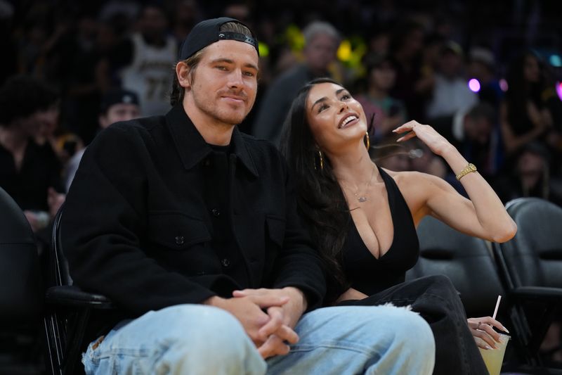 Oct 24, 2025; Los Angeles, California, USA; Los Angeles Chargers quarterback Justin Herbert (left) and girlfriend Madison Beer attend the game between the Minnesota Timberwolves and the Los Angeles Lakers at Crypto.com Arena. Mandatory Credit: Kirby Lee-Imagn Images
