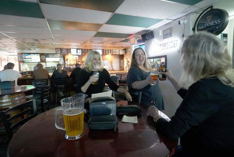 From left, Caren Gullick, owner of PJ’s Sports Pub in Thousand Oaks, shares drinks with her friends Tanya Gessler and Mary Cirona on May 27, 2026.