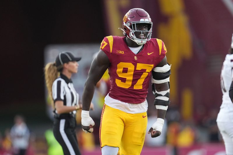 Aug 30, 2025; Los Angeles, California, USA; Southern California Trojans defensive tackle Jide Abasiri (97) celebrates after a sack as center judge referee Amanda Sauer watches against the Missouri State Bears in the second half at United Airlines Field at Los Angeles Memorial Coliseum. Mandatory Credit: Kirby Lee-Imagn Images