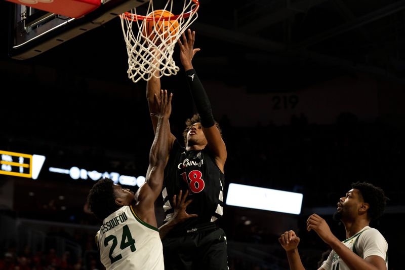 Cincinnati Bearcats forward Baba Miller (18) hits a layup over Baylor Bears guard Tounde Yessoufou (24) in the second half of the NCAA basketball game at Fifth Third Arena in Cincinnati on Jan. 28, 2026.