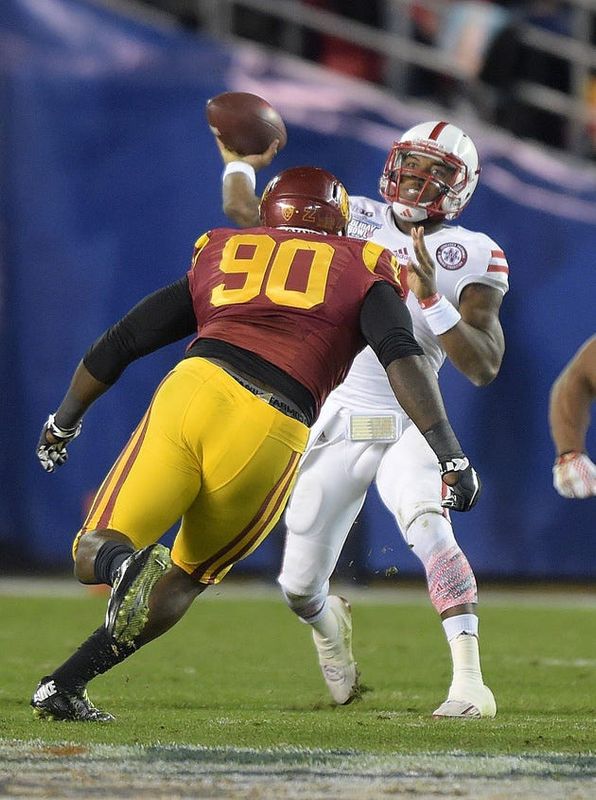 Dec 27, 2014; San Diego, CA, USA; Nebraska Cornhuskers quarterback Tommy Armstrong Jr. (4) is pressured by Southern California Trojans defensive tackle Claude Pelon (90) in the 2014 Holiday Bowl at Qualcomm Stadium. Mandatory Credit: Kirby Lee-USA TODAY Sports