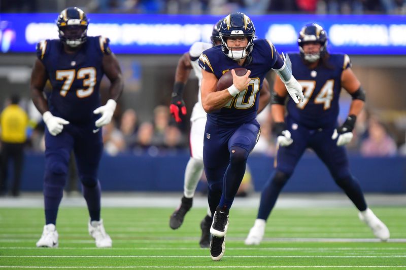 Dec 27, 2025; Inglewood, California, USA; Los Angeles Chargers quarterback Justin Herbert (10) carries the ball against the Houston Texans during the second half at SoFi Stadium. Mandatory Credit: Gary A. Vasquez-Imagn Images