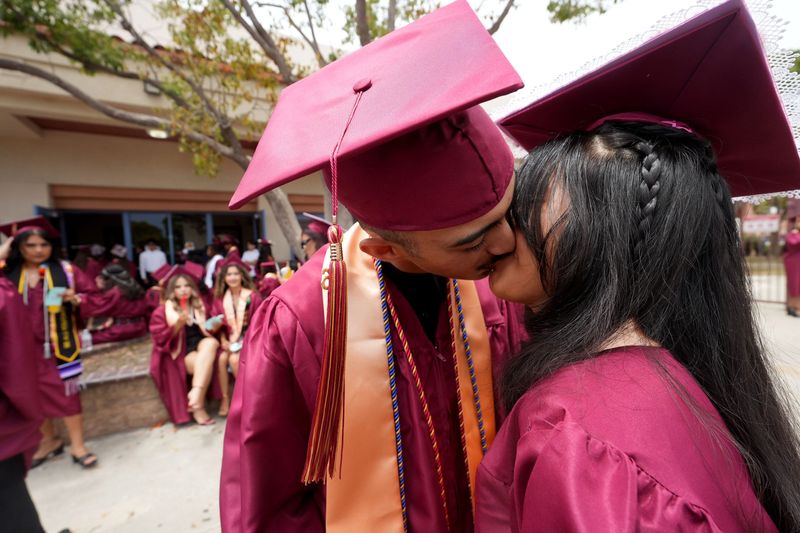 From left, Ayden De La Rosa kisses his girlfriend, Gabriela Morales-Ortiz, before the Oxnard High School graduation ceremony near the school's gym in Oxnard on June 3, 2026.