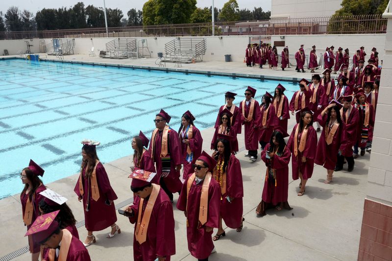 The Oxnard High School graduating class begins the commencement procession through the pool area and toward Bud Houser Field in Oxnard on June 3, 2026.