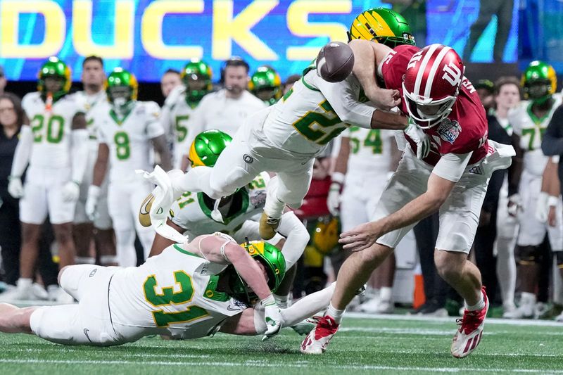 Indiana Hoosiers quarterback Fernando Mendoza (15) loses the ball to Oregon Ducks defensive back Jadon Canady (22) on Friday, Jan. 9, 2026, during the Peach Bowl and semifinal game of the College Football Playoff at Mercedes-Benz Stadium in Atlanta. The ball was recovered by the Indiana Hoosiers.