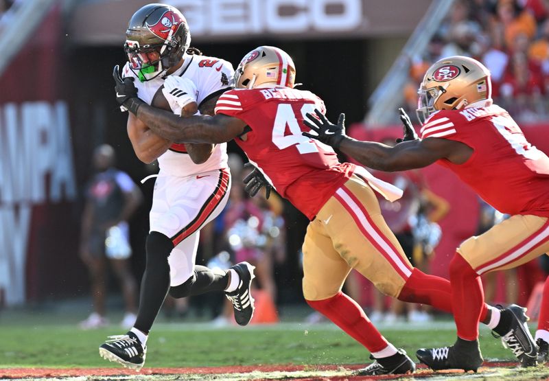Oct 12, 2025; Tampa, Florida, USA: Tampa Bay Buccaneers wide receiver Emeka Egbuka (2) runs for a gain past San Francisco 49ers linebacker Tatum Bethune (48) during the second quarter at Raymond James Stadium. Mandatory Credit: Jonathan Dyer-Imagn Images