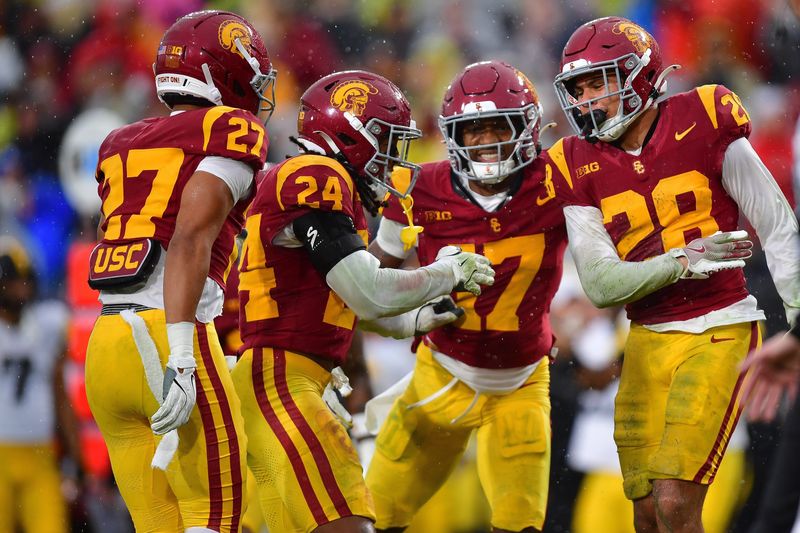 Nov 15, 2025; Los Angeles, California, USA; Southern California Trojans cornerback Alex Graham (27) safety Christian Pierce (24) cornerback Decarlos Nicholson (17) and safety Kennedy Urlacher (28) celebrate after Iowa Hawkeyes turn the ball over on fourth down during the second half at the Los Angeles Memorial Coliseum. Mandatory Credit: Gary A. Vasquez-Imagn Images