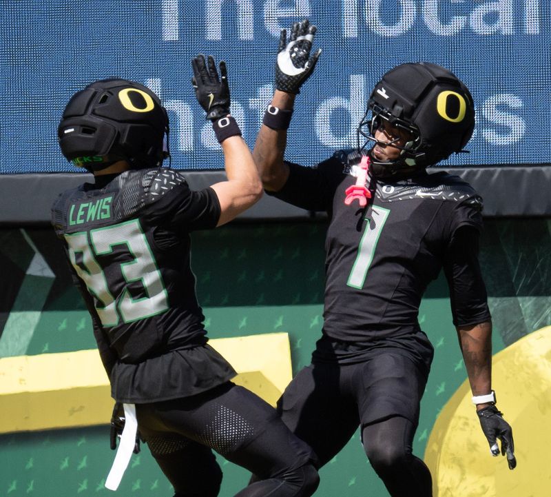 Oregonâ€™s Hudson Lewis, and Dakorien Moore celebrate a fourth-quarter touchdown for Combat Ducks during the Oregon Spring Game at Autzen Stadium in Eugene April 25, 2026