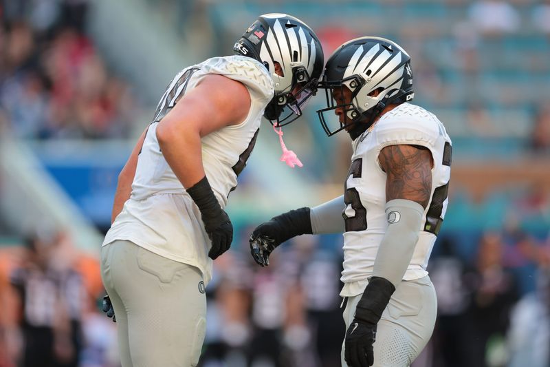 Jan 1, 2026; Miami Gardens, FL, USA; Oregon Ducks linebacker Teitum Tuioti (44) reacts with linebacker Devon Jackson (26) after a sack against the Texas Tech Red Raiders during the second half of the 2025 Orange Bowl and quarterfinal game of the College Football Playoff at Hard Rock Stadium. Mandatory Credit: Sam Navarro-Imagn Images