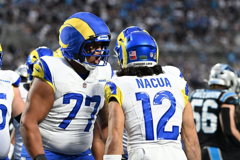 Jan 10, 2026; Charlotte, NC, USA; Los Angeles Rams wide receiver Puka Nacua (12) celebrates with offensive tackle Alaric Jackson (77) after scoring a touchdown in the second quarter in an NFC Wild Card Round game at Bank of America Stadium. Mandatory Credit: Bob Donnan-Imagn Images