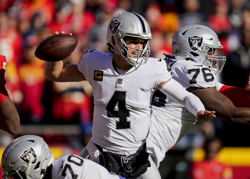 Dec 12, 2021; Kansas City, Missouri, USA; Las Vegas Raiders quarterback Derek Carr (4) throws a pass as guard John Simpson (76) and guard Alex Leatherwood (70) block during the first quarter against the Kansas City Chiefs at GEHA Field at Arrowhead Stadium. Mandatory Credit: Jay Biggerstaff-USA TODAY Sports