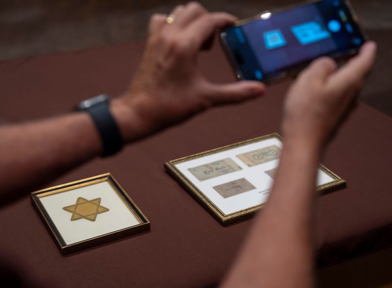 A community member gets a photo of two Holocaust artifacts donated to the Tolerance Education Center during a city council meeting in Rancho Mirage on Thursday, June 18. The items were donated to a Revivals thrift store by an unknown person.