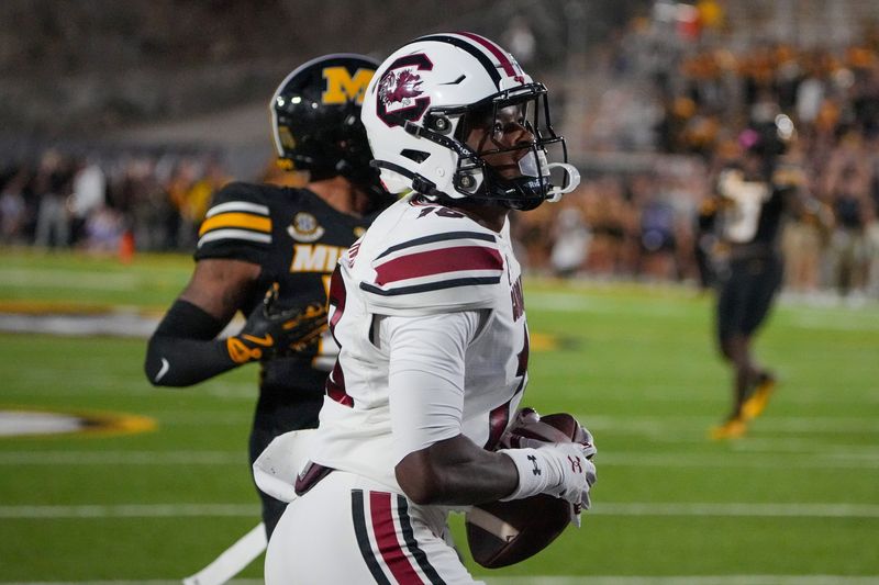 Sep 20, 2025; Columbia, Missouri, USA; South Carolina Gamecocks wide receiver Brian Rowe Jr. (18) catches a pass for a touchdown as Missouri Tigers cornerback Drey Norwood (12) looks on during the first half of the game at Faurot Field at Memorial Stadium. Mandatory Credit: Denny Medley-Imagn Images