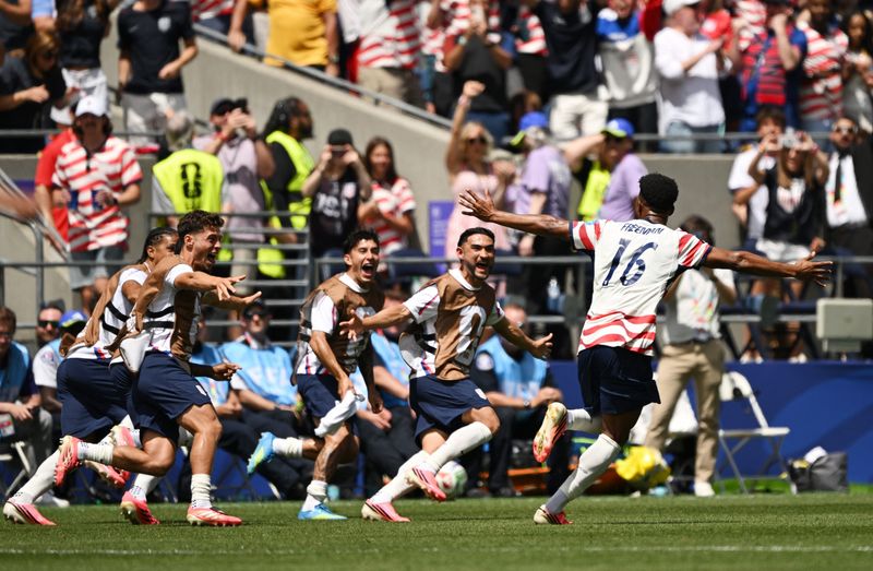 Alex Freeman of the U.S. celebrates scoring their second goal with teammates.