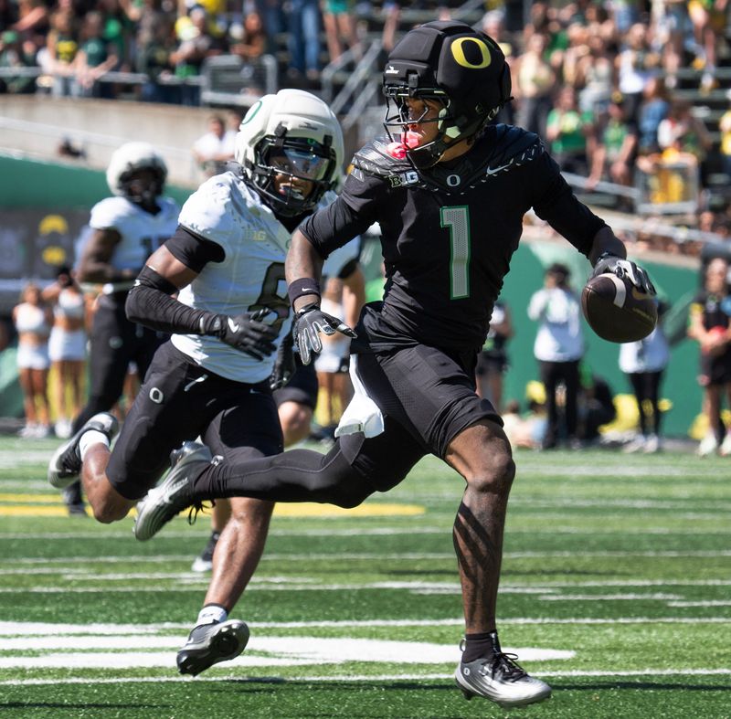 Oregonâ€™s Dakorien Moore, right, looks over his shoulder on the way to a fourth-quarter touchdown at the Oregon Spring Game in Autzen Stadium in Eugene April 25, 2026