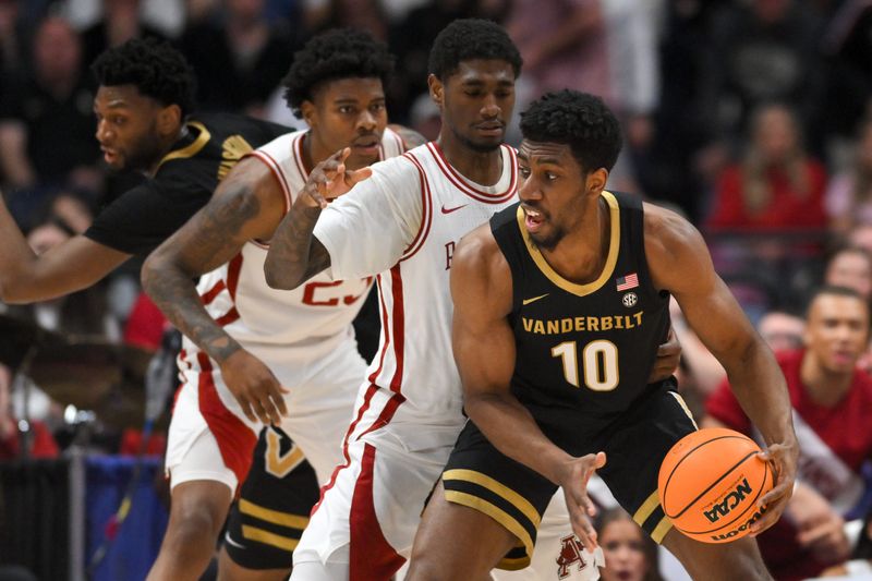 Mar 15, 2026; Nashville, TN, USA; Vanderbilt Commodores forward Ak Okereke (10) has the ball defended by Arkansas Razorbacks guard D.J. Wagner (21) in the first half during the men's SEC Conference Tournament Championship at Bridgestone Arena. Mandatory Credit: Steve Roberts-Imagn Images