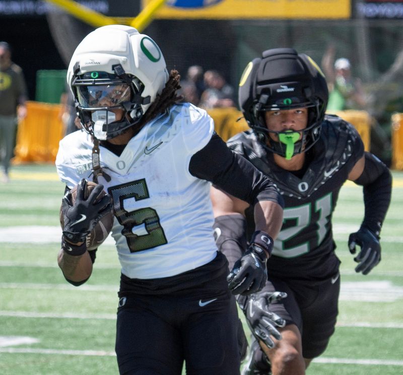 Oregon Fighting Ducks' Dierre Hill Jr., left, canâ€™t quiet evade the touch from Combat Duckâ€™s Aaron Flowers during the first half of the Spring Game at Autzen Stadium in Eugene April 25, 2026