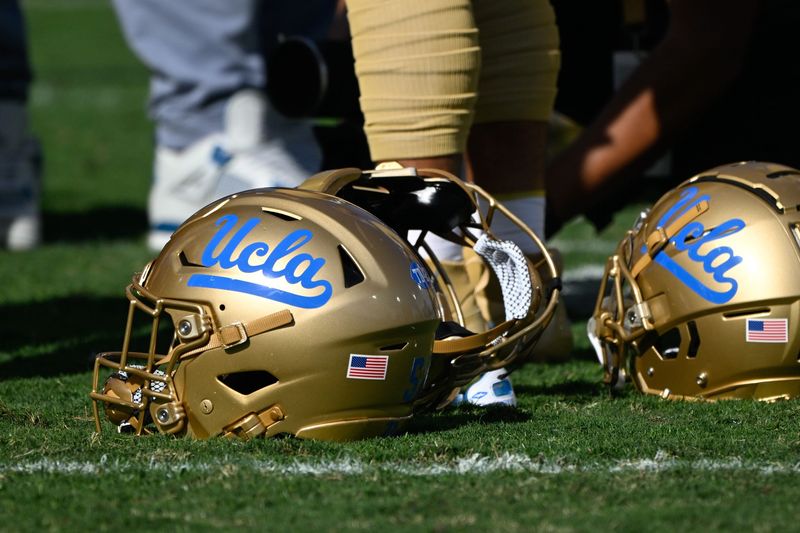 Nov 30, 2024; Pasadena, California, USA; UCLA Bruins helmets during pregame warmups before playing the Fresno State Bulldogs at Rose Bowl. Mandatory Credit: Robert Hanashiro-Imagn Images