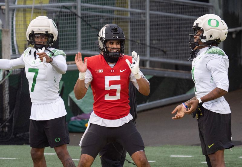 Oregonâ€™s receiver Evan Stewart, left, quarterback Dante Moore and Dakorien Moore dance during an open practice session leading up to their first-round CFP game against James Madison at Autzen Stadium in Eugene Dec. 14, 2025.