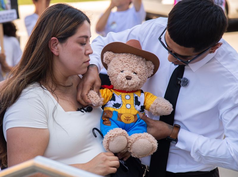 Daniela Lopez, left and her brother Felipe Lopez listen to a the voice of Felipe’s 4-year-old son Moses, recorded in a teddy bear. Friends and family of the Tracy toddler gathered on the steps of the San Joaquin County Courthouse in downtown Stockton on Jul. 14, 2026, to protest the reduction in charges of the man accused of the child’s 2020 murder.