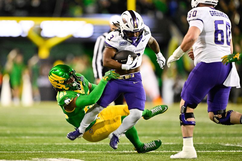 Dec 20, 2025; Eugene, OR, USA;  James Madison Dukes running back Wayne Knight (3) rushes as Oregon Ducks defensive back Aaron Flowers (21) defends during the second quarter at Autzen Stadium. Mandatory Credit: Troy Wayrynen-Imagn Images