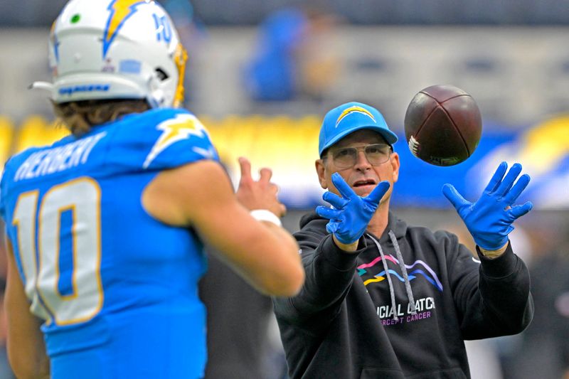 Oct 27, 2024; Inglewood, California, USA;  Los Angeles Chargers quarterback Justin Herbert (10) warms up with head coach Jim Harbaugh prior to the game against the Los Angeles Chargers at SoFi Stadium. Mandatory Credit: Jayne Kamin-Oncea-Imagn Images