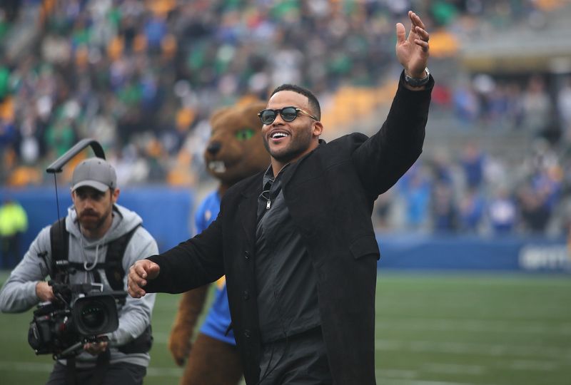 Former Pittsburgh Panther and retired NFL defensive tackle Aaron Donald waves to the crowd while walking out onto the field during his jersey number retirement ceremony during halftime of the Pittsburgh Panthers vs Notre Dame Fighting Irish game at Acrisure Stadium in Pittsburgh, PA on November 15, 2025.