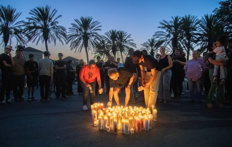 Family, friends and coworkers of manager Ashely Garibay place lit candles in the parking lot of the In-N-Out Burger on March Lane in Stockton on Aug. 5, 2026. Garibay was killed by a mass shooter at the Twin Falls In-N-Out where she was training employees to open the new restaurant.