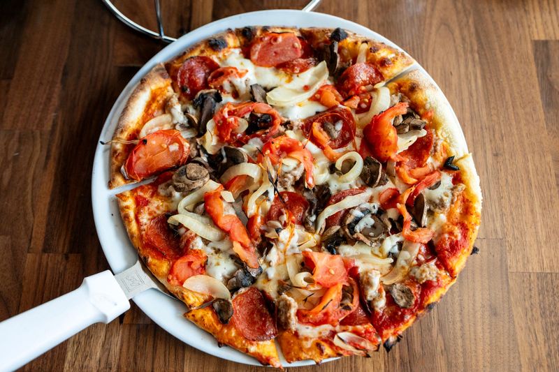 Giusseppes Pizzeria house special pizza with sausage, pepperoni, mushrooms, tomatoes, and white onion in Palm Springs, Calif., August 5, 2026.
