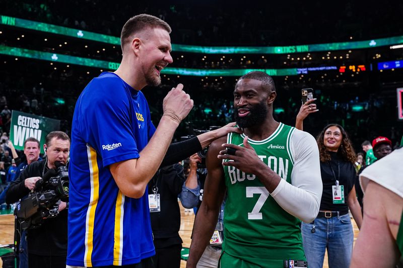 Mar 18, 2026; Boston, Massachusetts, USA; Boston Celtics guard Jaylen Brown (7) talks with Golden State Warriors center Kristaps Porzingis (7) after the game at TD Garden. Mandatory Credit: David Butler II-Imagn Images