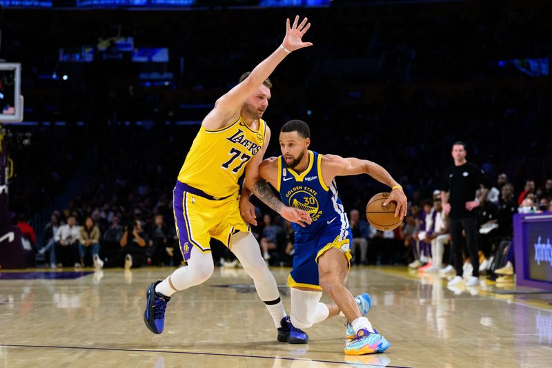 Oct 21, 2025; Los Angeles, California, USA; Golden State Warriors guard Stephen Curry (30) drives against Los Angeles Lakers guard Luka Doncic (77) during the second half at Crypto.com Arena. Mandatory Credit: William Liang-Imagn Images