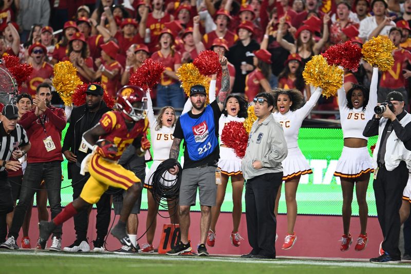 Nov 4, 2023; Los Angeles, California, USA; USC cheerleaders and fans react as USC Trojans wide receiver Tahj Washington (16) carries the ball for a touchdown against the Washington Huskies during the second quarter at United Airlines Field at Los Angeles Memorial Coliseum. Mandatory Credit: Jonathan Hui-USA TODAY Sports