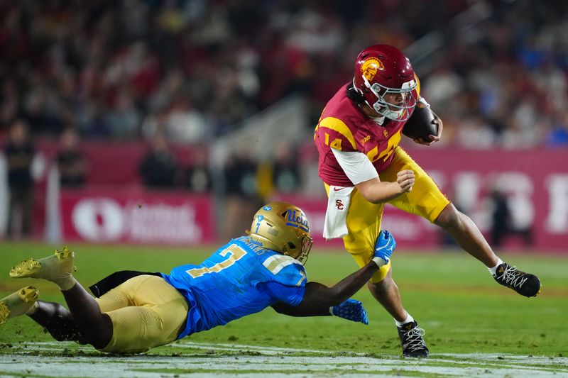 Nov 29, 2025; Los Angeles, California, USA; Southern California Trojans quarterback Jayden Maiava (14) carries the ball against UCLA Bruins defensive back Aaron Williams (7) in the first half at United Airlines Field at Los Angeles Memorial Coliseum. Mandatory Credit: Kirby Lee-Imagn Images