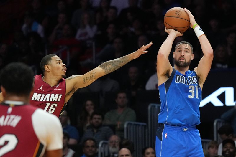 Nov 24, 2025; Miami, Florida, USA; Dallas Mavericks guard Klay Thompson (31) takes a three-point shot as Miami Heat forward Keshad Johnson (16) closes in during the second half at Kaseya Center. Mandatory Credit: Jim Rassol-Imagn Images