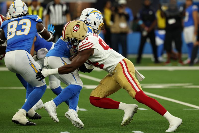 Aug 20, 2026; Inglewood, California, USA;  San Francisco 49ers defensive end Romello Height (94) tackles Los Angeles Chargers running back Keaton Mitchell (34) during the first quarter at SoFi Stadium. Mandatory Credit: Kiyoshi Mio-Imagn Images