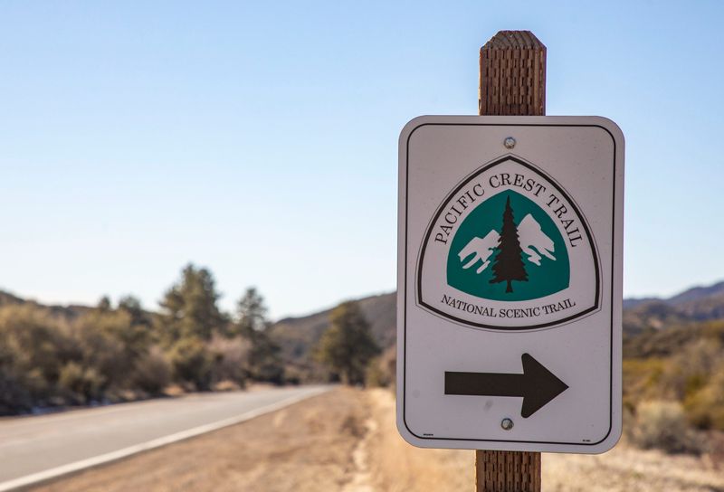 A sign alongside Highway 74 marks the spot where the Pacific Crest Trail resumes after crossing the highway in Mountain Center, Calif., Tuesday, March 1, 2022.