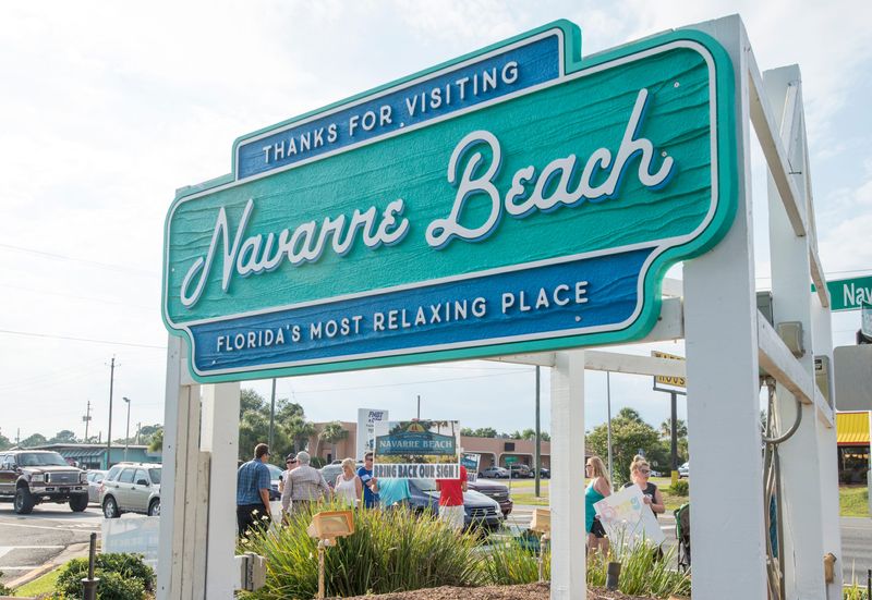A small group of protesters try to raise support to bring back the old Navarre Beach sign to the corner of Navarre Parkway and Navarre Beach Causeway on Friday, June 9, 2017.